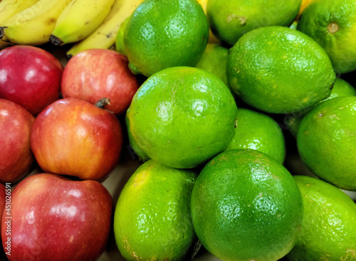 Close up of lime and red apples with ripe bananas at the farmer's market