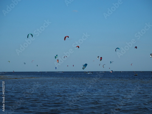 Many large colorful kites against the blue sky