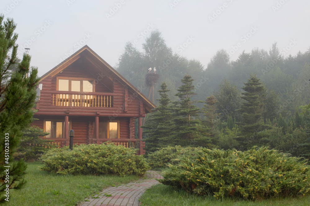 wooden house among the trees at sunrise in summer wooden house among the trees at sunrise in summer