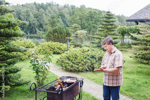 man is grilling in garden in summer