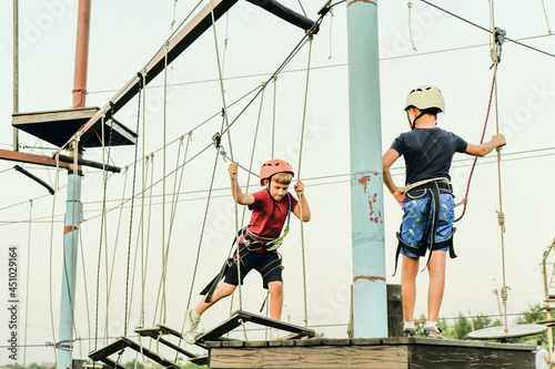 Two boys on a rope road in a sports extreme park.