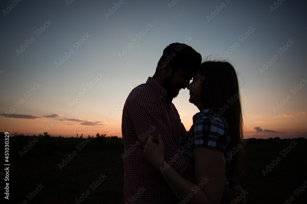 Embracing couple in rays of setting sun