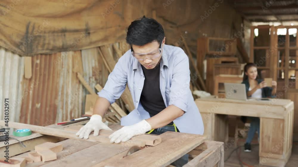 Two asian carpenters in a construction workshop. business man and woman working together woodwork.Friends in a construction workshop, learning carpentry. Two asian carpenters in a construction workshop. business man and woman working together woodwork.Friends in a construction workshop, learning carpentry.