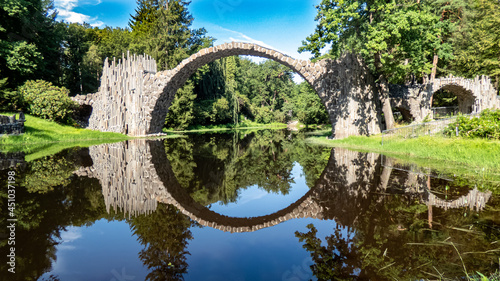 Rakotzbrücke Kromlau mit kreisförmiger Spiegelung im Wasser im Rhododendronpark