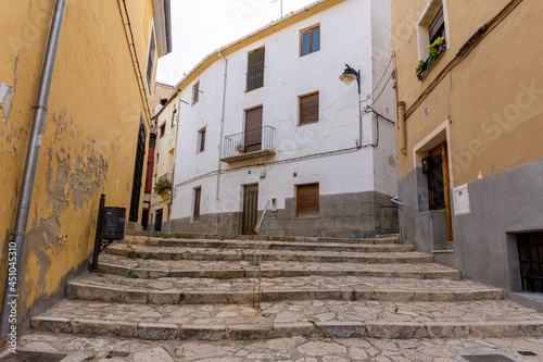 narrow street with stone stairs and old buildings. © MiguelAngel