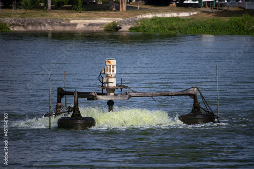 An electric aerator in a pond or river that uses a motor and a large propeller to spin. photo