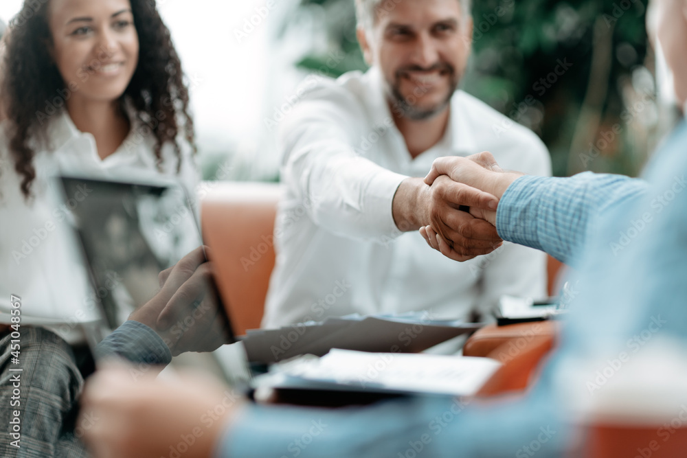 smiling businessman shaking hands with his business partner.