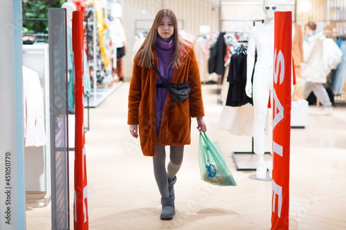 Young woman goes through a security anti-theft framework in a store