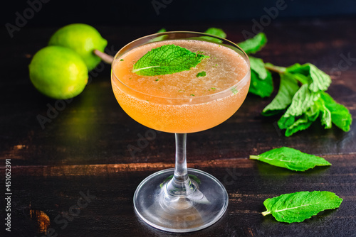 Old Cuban Cocktail Made with Rum, Mint, and Sparkling Wine: A cocktail made with dark rum and served in a coupe glass photo