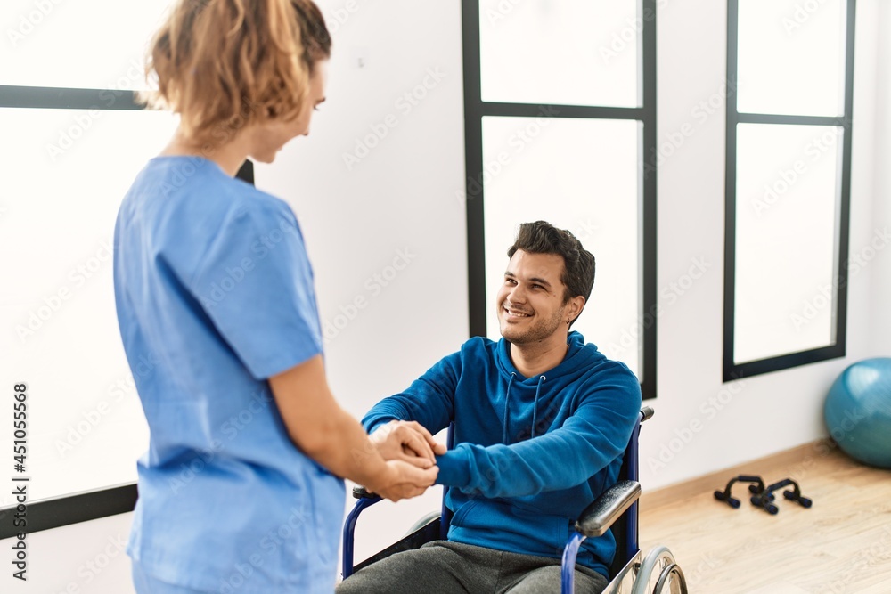 Young disabled man and physiotherapist smiling happy shaking hands at the clinic. Young disabled man and physiotherapist smiling happy shaking hands at the clinic.