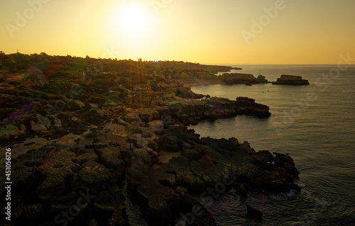 Atlanic ocean coastline in Portugal Algarve near Albufeira, rocky cliffs with visible erosion, landscape aerial photo during sunrise. Beautiful holiday place with the sea, rocks outdoor trekking