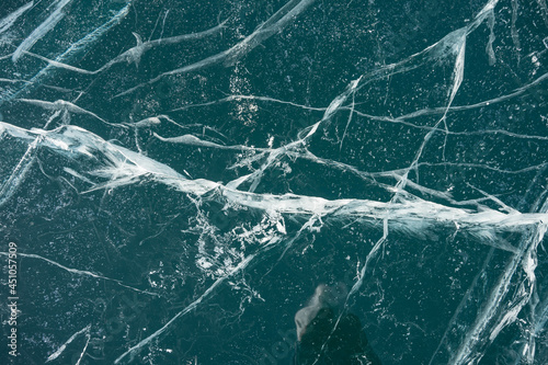 cracks in transparent ice in winter on the lake
