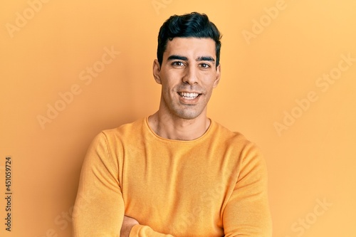 Handsome hispanic man wearing casual clothes happy face smiling with crossed arms looking at the camera. positive person.