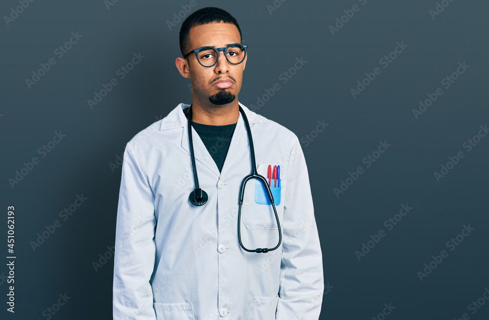 Young african american man wearing doctor uniform and stethoscope depressed and worry for distress, crying angry and afraid. sad expression.