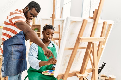 African american painter couple with serious expression painting at art studio.