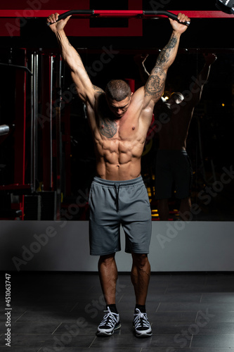 Bodybuilder Performing Hanging Leg Raises Exercise Ab Exercises © Jale Ibrak