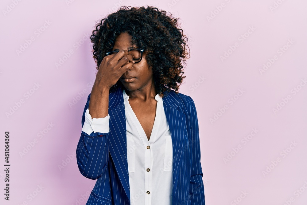 Young african american woman wearing business clothes and glasses tired rubbing nose and eyes feeling fatigue and headache. stress and frustration concept.