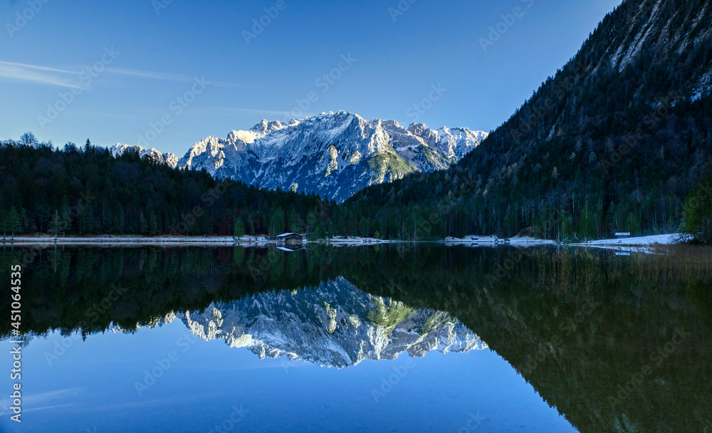 Alpiner Ferchensee mit verschneiter Bergpanorama Landschaft, die sich im Wasser und Waldhintergrund spiegelt