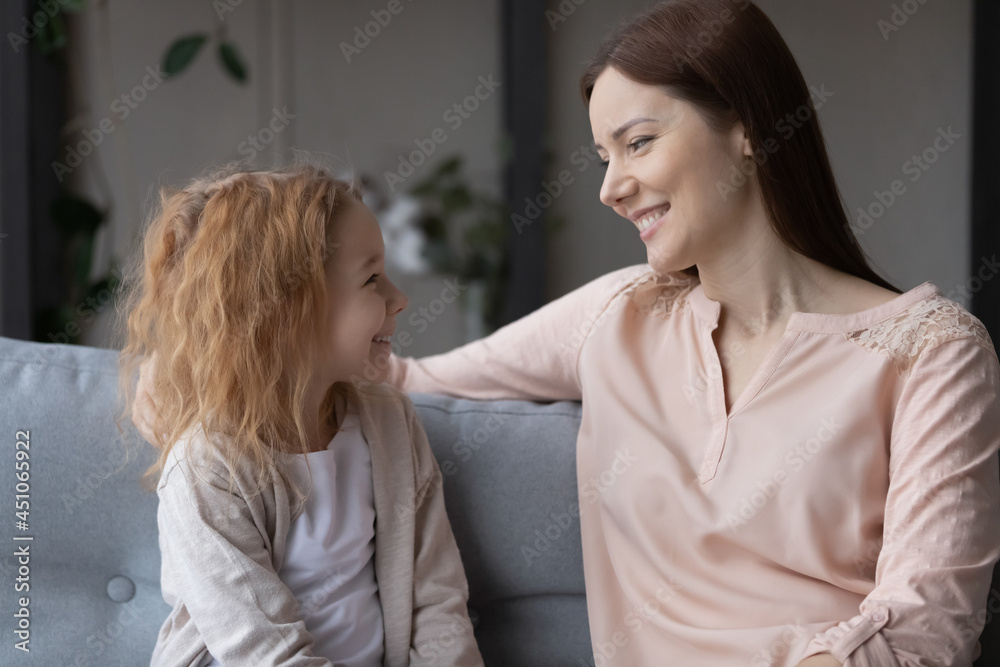 Smiling loving young Caucasian mother relax on couch with teen little daughter chat and talk. Happy caring mom rest on sofa with small teenage girl child, enjoy good leisure family weekend together. Smiling loving young Caucasian mother relax on couch with teen little daughter chat and talk. Happy caring mom rest on sofa with small teenage girl child, enjoy good leisure family weekend together.