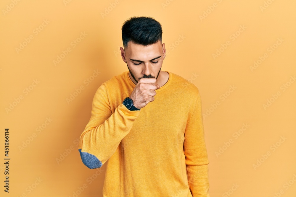 Young hispanic man with beard wearing casual winter sweater feeling unwell and coughing as symptom for cold or bronchitis. health care concept. Young hispanic man with beard wearing casual winter sweater feeling unwell and coughing as symptom for cold or bronchitis. health care concept.