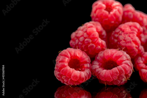 Several berries of ripe red raspberries, close-up, isolated on black.