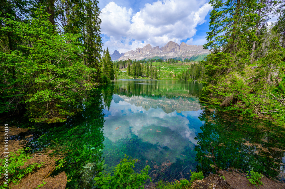 Paradise scenery at Karersee (Lago di Carezza, Carezza lake) in Dolomites of Italy at Mount Latemar, Bolzano province, South tyrol. Blue and crystal water. Travel destination of Europe. Paradise scenery at Karersee (Lago di Carezza, Carezza lake) in Dolomites of Italy at Mount Latemar, Bolzano province, South tyrol. Blue and crystal water. Travel destination of Europe.