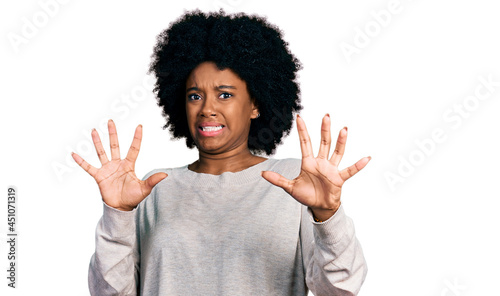 Young african american woman wearing casual clothes afraid and terrified with fear expression stop gesture with hands, shouting in shock. panic concept.