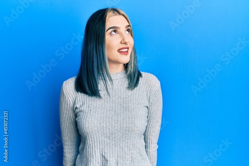 Young modern girl wearing casual sweater looking to side, relax profile pose with natural face and confident smile.