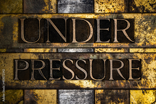 Under Pressure text message on textured grunge copper and vintage gold background photo