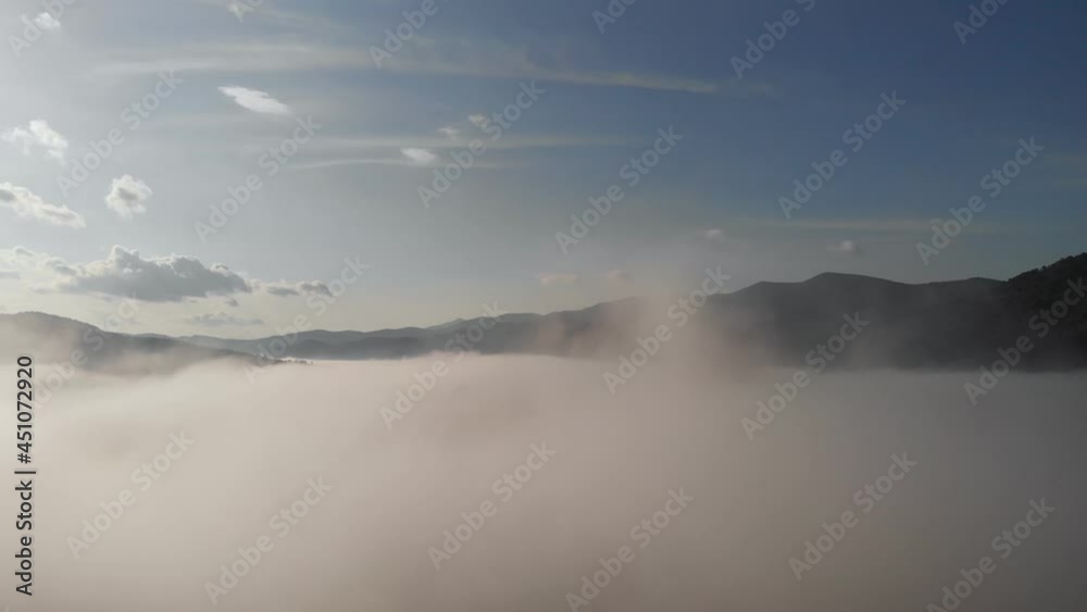 Aerial drone flight view over low clouds and morning mist covered mountain slopes at sunrise. Sunrise in mountains clouds. Inspiration concept. Aerial drone flight view over low clouds and morning mist covered mountain slopes at sunrise. Sunrise in mountains clouds. Inspiration concept.