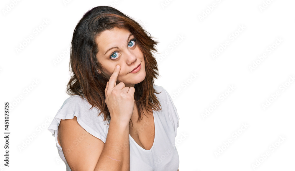 Young plus size woman wearing casual white t shirt pointing to the eye watching you gesture, suspicious expression Young plus size woman wearing casual white t shirt pointing to the eye watching you gesture, suspicious expression