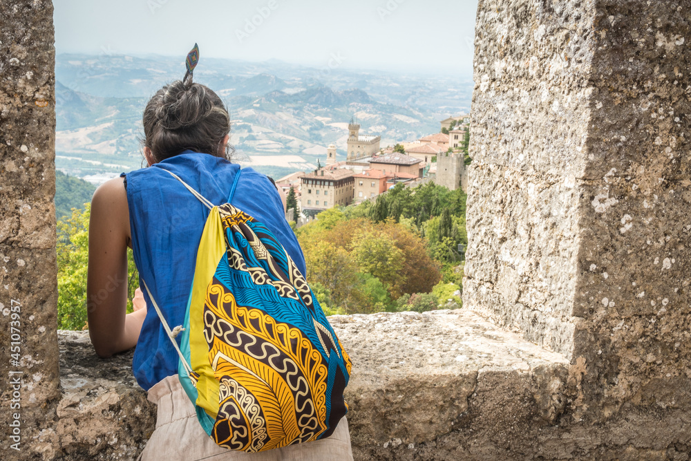 Fototapeta premium A Girl looking out a window of a medieval castle in San Marino, Italy, Europe