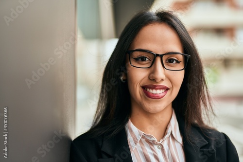 Young hispanic businesswoman smiling happy standing at the city.