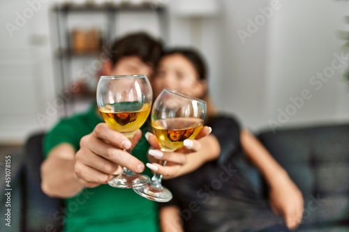 Young caucasian couple smiling happy drinking champagne at home.