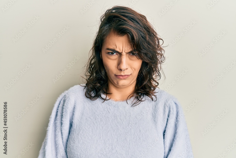 Young hispanic woman wearing casual winter sweater skeptic and nervous, frowning upset because of problem. negative person. Young hispanic woman wearing casual winter sweater skeptic and nervous, frowning upset because of problem. negative person.