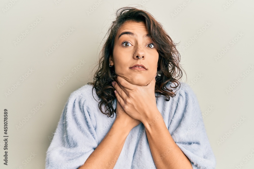 Young hispanic woman wearing casual winter sweater shouting and suffocate because painful strangle. health problem. asphyxiate and suicide concept. Young hispanic woman wearing casual winter sweater shouting and suffocate because painful strangle. health problem. asphyxiate and suicide concept.