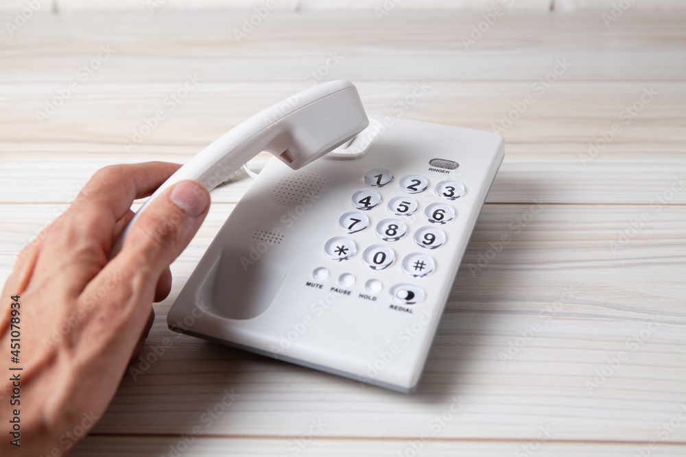 hand holding a home phone receiver hand holding a home phone receiver