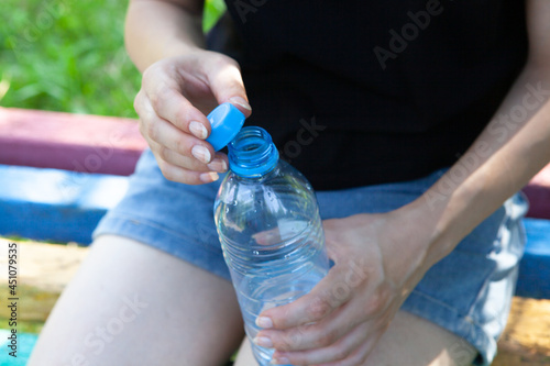 girl holding a bottle of water in the park