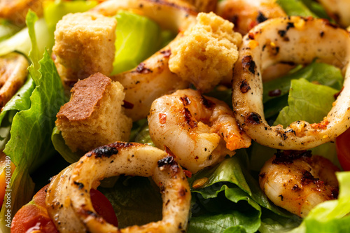 Grilled squid or calamari and prawns salad with garlic croutons and cherry tomatoes