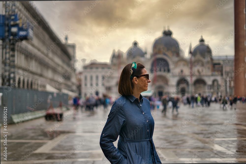 Young woman walking through St. Mark's Square, Venice, Italy.