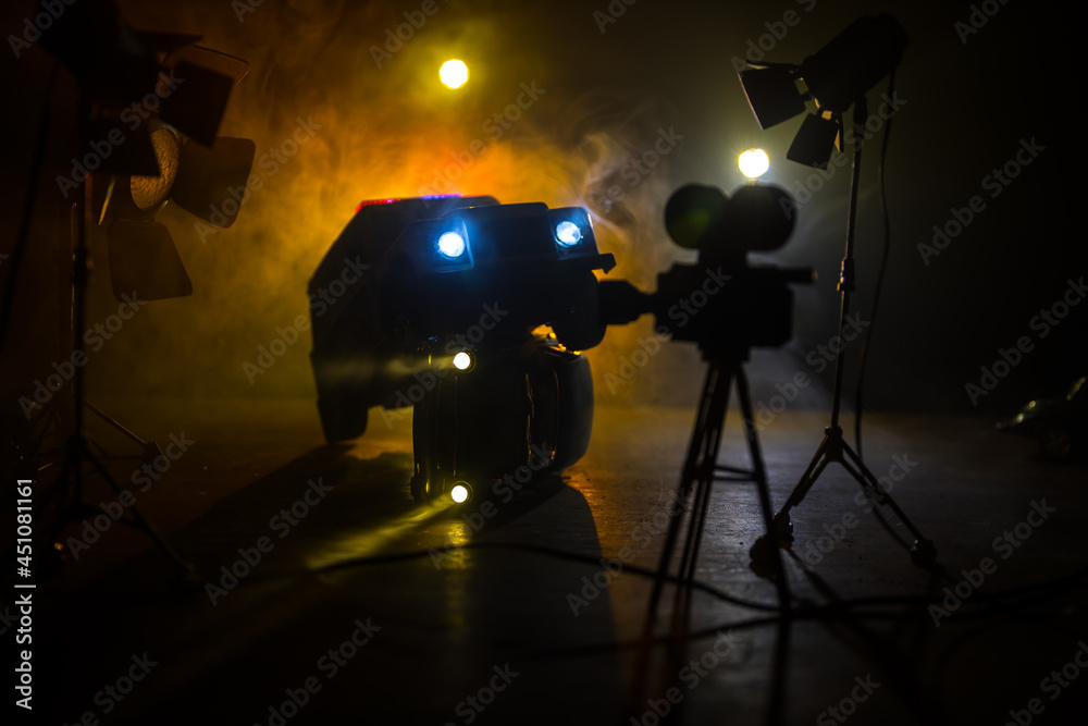 Action movie concept. Police cars and miniature movie set on dark toned background with fog. Police car chasing a car at night. Scene of crime accident.