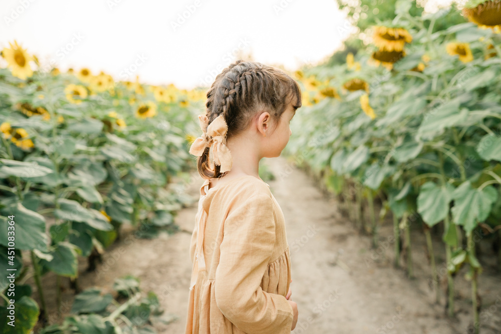 Local travel. Six year girl wearing natural linen dress pastel color in sunflower field at summer, outdoor lifestyle. Freedom concept Local travel. Six year girl wearing natural linen dress pastel color in sunflower field at summer, outdoor lifestyle. Freedom concept