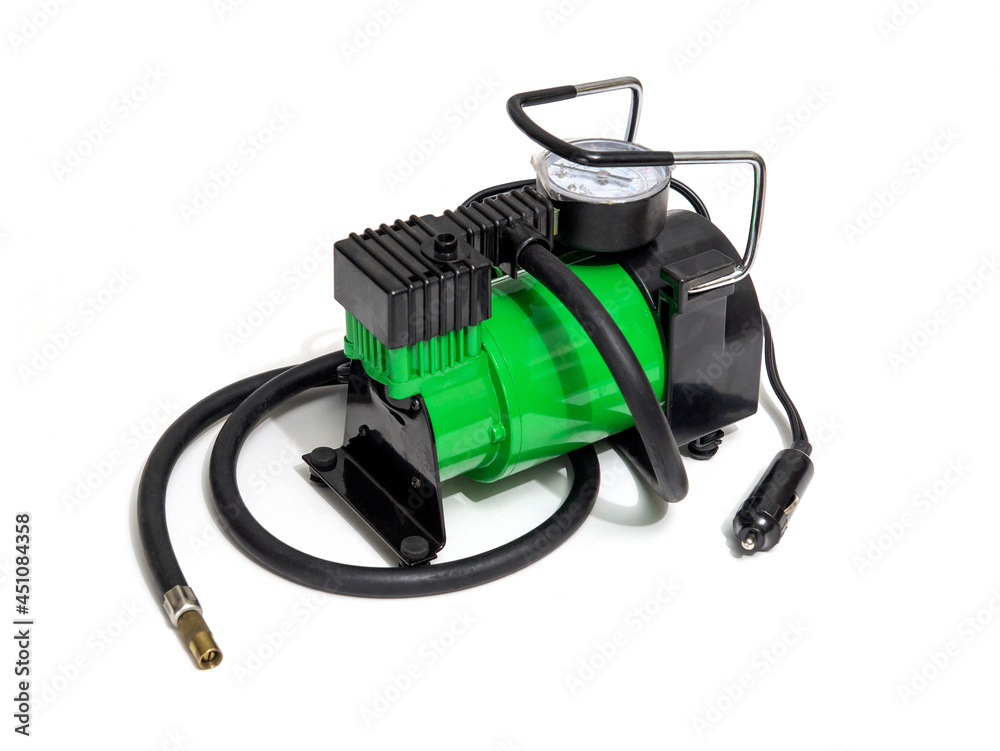 Car pump with manometer, green air compressor on white background. Inflating the wheels with air in the car
