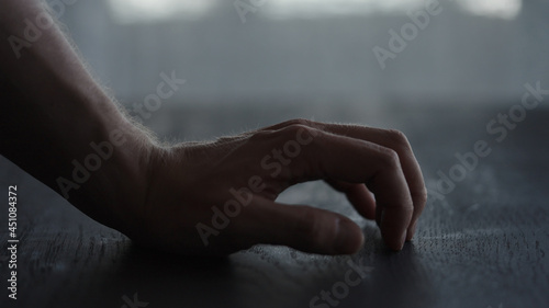 Canvas Print Man tapping fingers on black oak table with back light