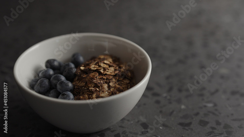 granola with yogurt and blueberries in white bowl