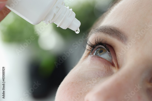 Canvas Print Woman dripping into her eyes with antibacterial drops closeup