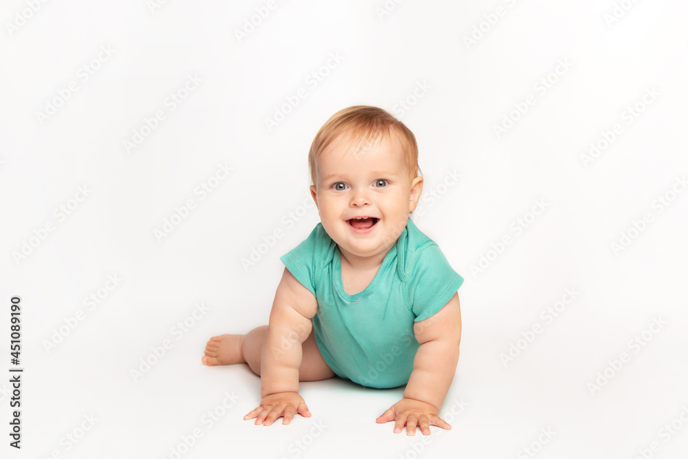 Cute small caucasian toddler baby boy child crawl on white studio floor. Smiling little infant kid wearing a green t-shirt explore world. Childcare and upbringing concept. Cute small caucasian toddler baby boy child crawl on white studio floor. Smiling little infant kid wearing a green t-shirt explore world. Childcare and upbringing concept.