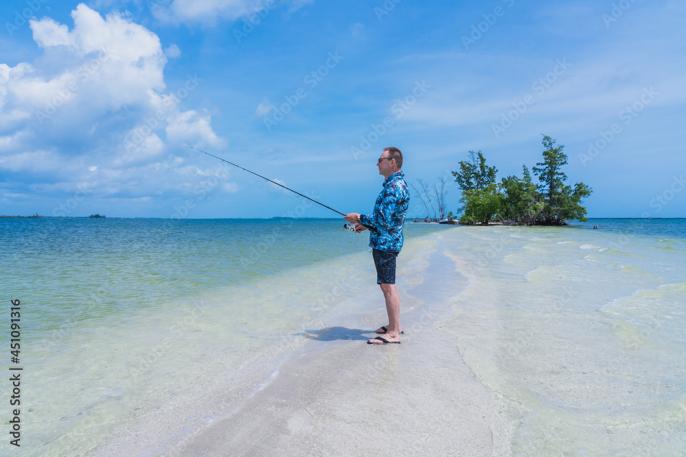 Caucasian man 60 years old with a fishing rod in his hands while