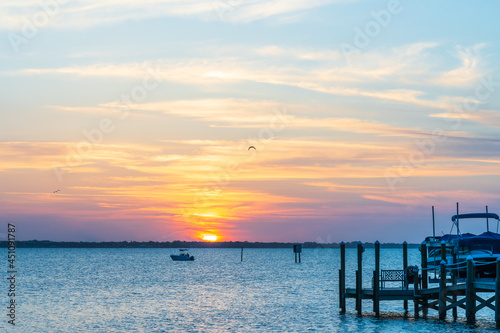 Orange sunset on Indian River  Vero Beach  Florida. Boats and wooden piers on the horizon