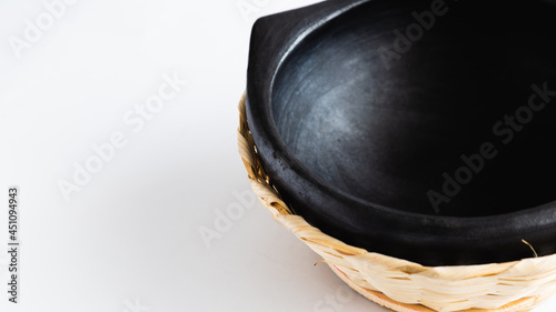 black clay plate in a wooden basket, very traditional to serve food, used in Colombia.